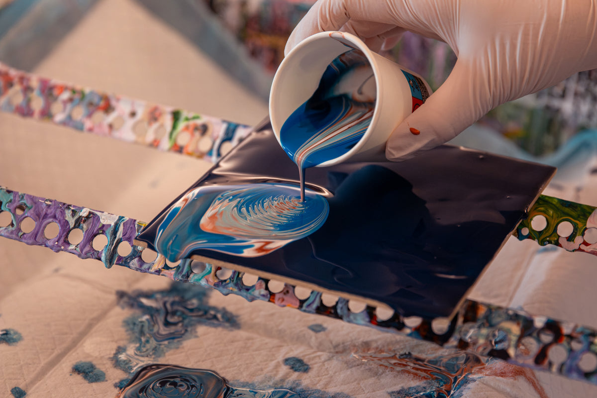 Acryl Pouring Farbe fließt aus Becher im Kurs